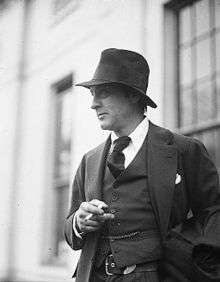 Picture of Barrymore outside, from the waist up, pensively smoking a cigarette and facing to the left
