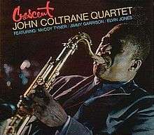 A slanted photograph of Coltrane playing saxophone in a blue suit facing the left. The top left corner of the cover features the title of the album in red script with by the words "John Coltrane Quartet" in yellow beneath it and "Featuring McCoy Tyner/Jimmy Garrison/Elvin Jones" underneath that in blue.