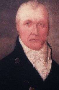 Portrait of the head of man wearing black coat and a white scarf around his neck.