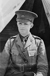 A young man wearing military uniform in front of a tent