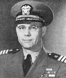 Head and shoulders of man in his forties, wearing glasses and a World War II style U.S. naval officer's uniform