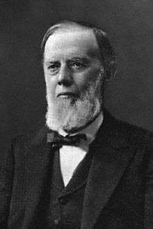 A black and white photographic portrait of a bearded Edwin Maxwell in his later years.