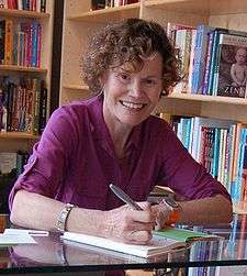 Blume smiling while signing a book
