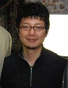 A photograph of a Japanese man wearing glasses.