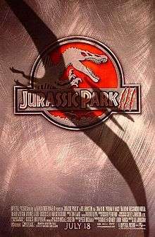 Film poster with a logo at center of a skeleton of a Spinosaurus, with its mouth wide open and hands lifted up. The logo's background is red, and right below it is the film's title. A shadow covers a large portion of the film poster in the shape of a flying Pteranodon. At the bottom of the image are the credits and release date.