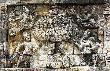 The divine Kalpavriksha tree in mythology, a stone carving of a tree with mythical characters surrounding it.