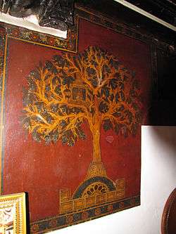 Artisitc representation of the Kalpavriksha in Jainism. A wall painting of a tree on red backdrop.