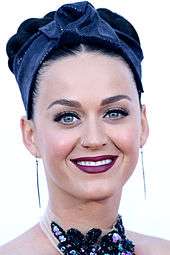 Katy Perry looking straight and smiling.