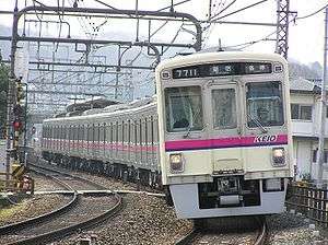 White commuter train with purple stripe