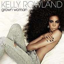 A woman lies on bed of white linen. She is sporting a large black perm and is picture half naked. She uses her arms to shield her breasts from the camera and is seen wearing a pair of striped gray and white denim jeans which are torn on one leg. At the top of the cover, in a simple gray font, reads the artist's name: Kelly Rowland. Directly underneath this in the same font, this time black, reads the name of the song: Grown Woman.