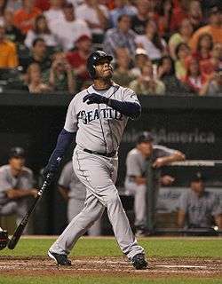 Ken Griffey, Jr. batting as a Seattle Mariner. In the background is the Mariner's dugout.