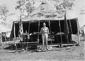 A man standing in front of a large tent.