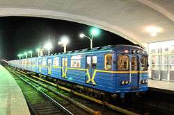 Blue mass-transit train pulling into a station
