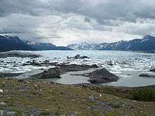A plain covered in ice and water, surrounded by mountains