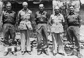 Full-length portrait of five men in military uniforms