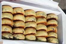 24 buns in golden brown are put in a white rectangular box. The buns are arranged like an abacus.