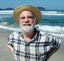 Man with a beard and straw hat on a beach