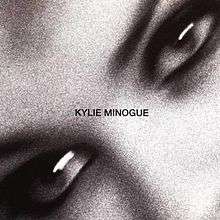 A black-and-white, and motion-blurred image of a woman's (Kylie Minogue) eyes. The song title and woman's name is superimposed on the image.