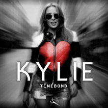 A black-and-white image of a woman behind a motion-blurred street, with the title "Kylie" and "Timebomb" superimposed on her. The heart shape on her jacket is coloured red.