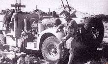 truck with an array of machine guns mounted, with a man in the foreground