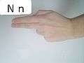 A flat hand (like an ASL 'U' or informal 'N') pointed to the side rather than down. Palm faces speaker.