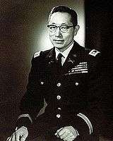 Korean American male wearing a United States Army Dress Blue uniform and eyeglasses