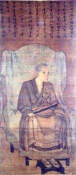 Monk seated on a chair holding a stick-like object in his right hand in three-quarter view. Above the painting there is Chinese text.