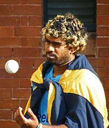 Lasith Malinga tossing a cricket ball during practice.