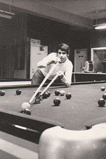 Young Laucke playing a snooker shot using a rack