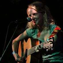Laura Slade Wiggins smiling, playing an acoustic guitar 12 September 2010 at Silverlake Lounge