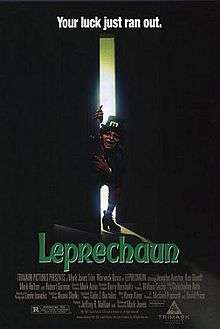 Actor Warwick Davis, dressed in heavy make-up as a leprechaun, opens a door and lights up a dark room
