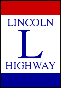 A large, rectangular tricolor. The middle portion says "Lincoln Highway" on two lines and a large L is positioned between the lines.