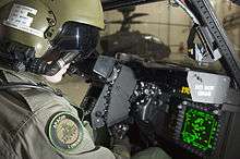 Pilot sitting in cockpit looking at controls