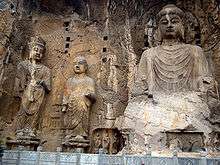 Carved Buddhist deities in a rock face.