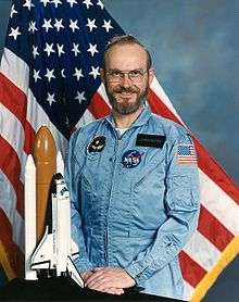 Man in a beard and glasses in a space suit