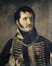 Painting of a black-haired man with long sideburns and a moustache. He wears a dark hussar-style uniform with yellow frogging.