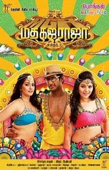 Against a vibrant background of rays and multi-colored marquee lights, a man stands with his arms around the waists of two women who stand on his left and right side. He is wearing a cap, sunglasses and an open-front shirt. The women have long, loose hair and bare mid-riffs. In Hindi, the name of the film, Madha Gaja Raja, is printed in bright yellow and gold lettering above their heads.