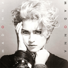 Madonna's image with her right hand placed on her right cheek and with the left hand, she holds on to a number of chains wound on her neck.