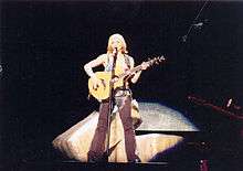 Image of Madonna playing the acoustic guitar during a concert
