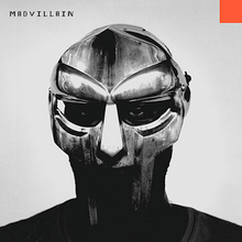 Grayscale photo of DOOM's face behind his metal mask, with word "MADVILLAIN" in pixelated black font at the top left corner and small orange square at the top right corner.