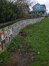 Tiles of children's artwork covering a low wall in Mallory Meadows Park