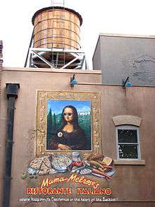 A photograph of the exterior of a building with "Mama Melrose's RISTORANTE ITALIANO where Italy meets California in the heart of the Backlot!" painted on the side