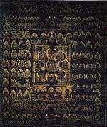 A large number of golden deities arranged in regular fashion on a dark-blue background. The deity in the center is surrounded by eight deities arranged like petals. These nine deities in flower-shape are surrounded by a square.