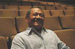 A man is sitting on a seat inside a theater