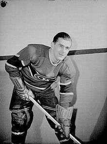 Maurice Richard poses for a photographer while wearing his full Canadiens uniform.