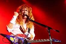 Photo of a long-haired man with an angular electric guitar