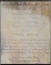 Memorial plaque which reads: Here lye interred in one grave the bodies of William Beavis, George Crow, John Dennis, Isaac Harley and Thomas South who were all executed at Ely on the 28th day of June 1816 having been convicted at the special assizes held there of diverse robberies during the riots at Ely & Littleport in the month of May in that year. May their awful fate be a warning to others.