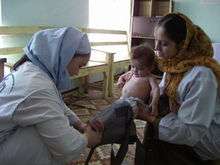 Woman with infant attending maternal health clinic in Afghanistan