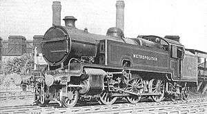 A black-and-white photograph of a 2-6-4 tank locomotive in three-quarter view. The side tank closest to the camera has the word "Metropolitan" painted on it.