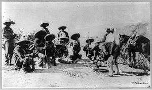  A group of 14 armed men, eight of them crouching down, in sombreros and holding rifles